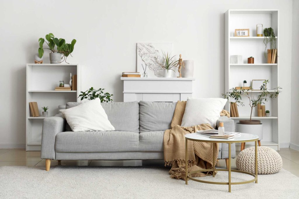 Contemporary living room with neutral tones, a sleek sofa, and elegant wooden staircase.